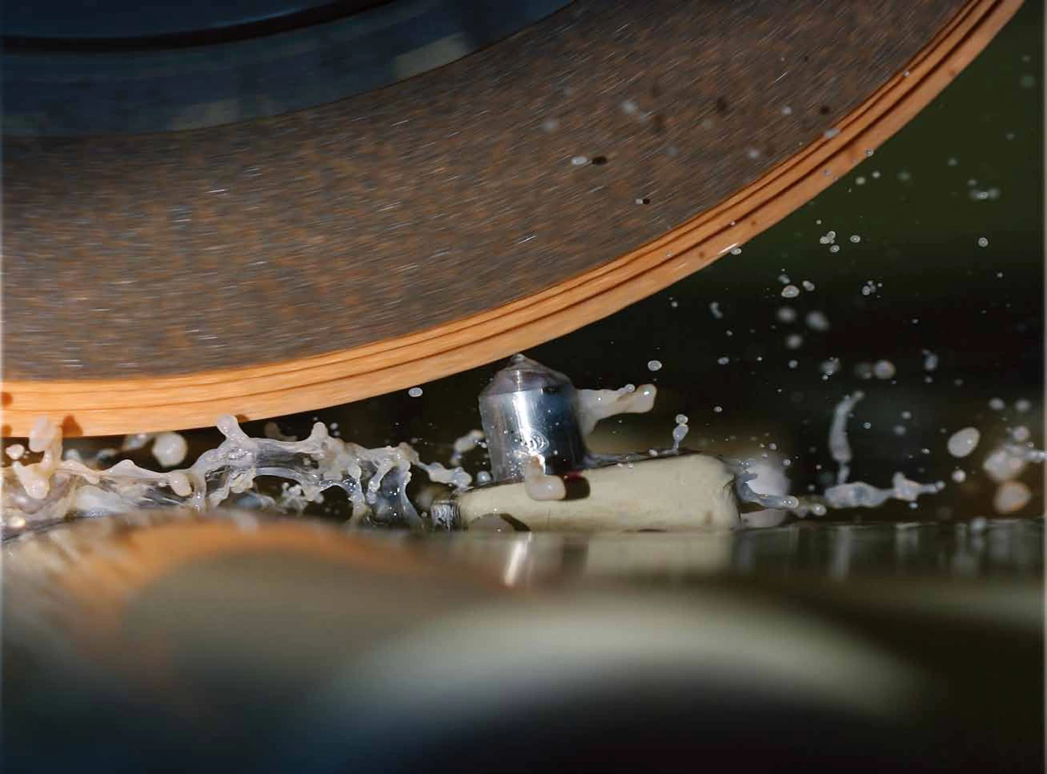 Stationary diamond dresser in contact with the grinding wheel