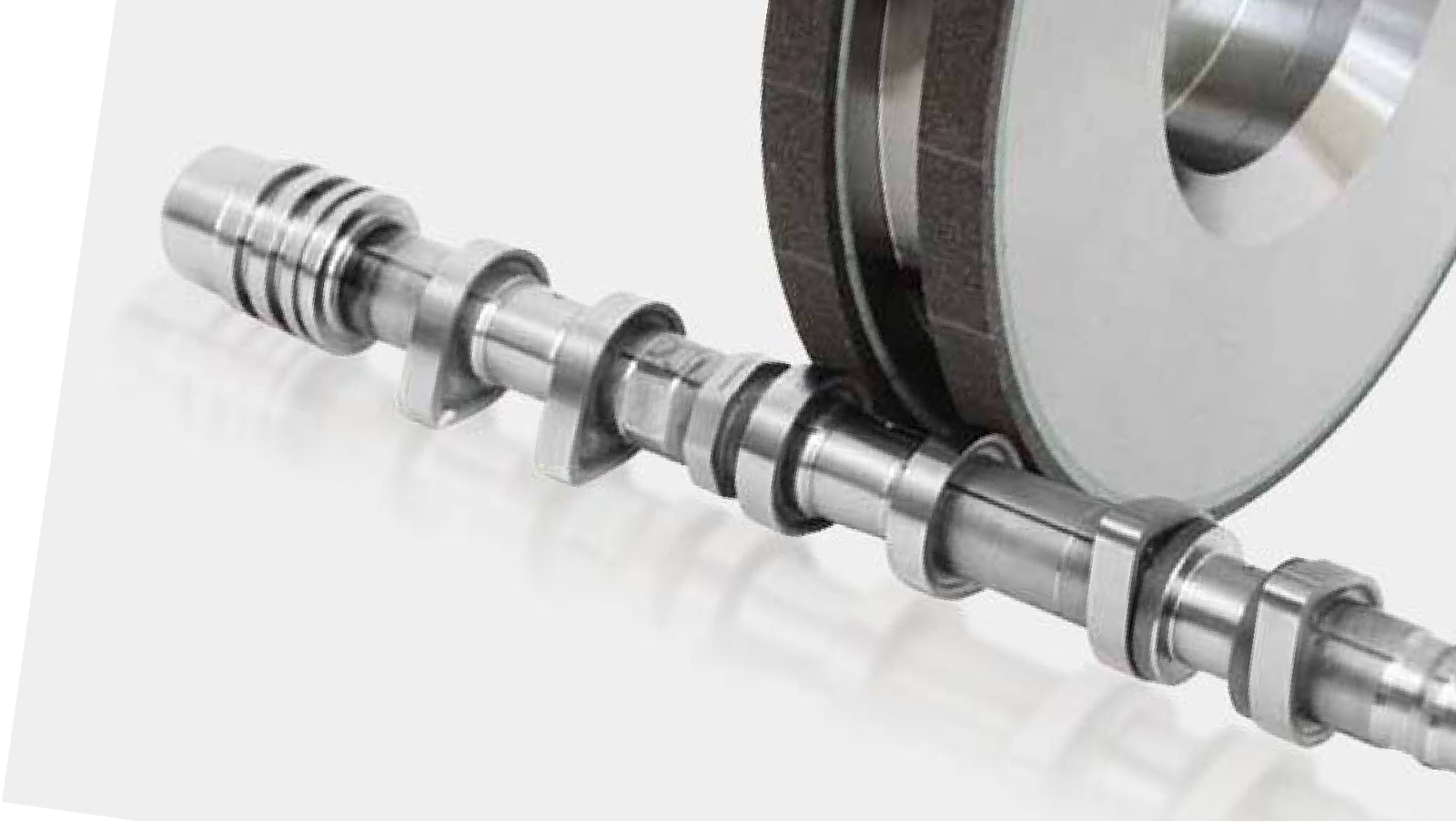 Camshaft and grinding wheel in the machining arrangement.
