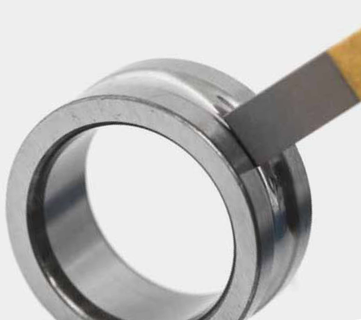 Honing stone in contact with a bearing ring